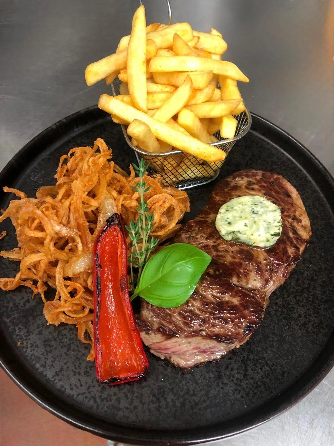 Apfelbaum – Restaurant – Dieses Gericht ist ein gegrilltes Steak, serviert mit Pommes frites.